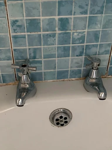 The same end of the bath before, with an old pair of chrome cross head pillar taps, the cap missing from the top of the left one